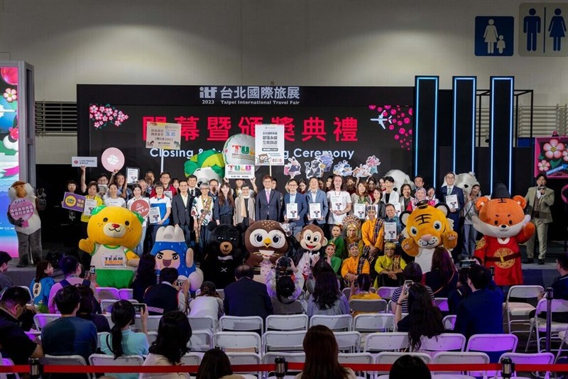 Teilnehmer und Maskottchen von Reisebüros stellen sich während der Abschlusszeremonie der Internationalen Reisemesse 2023 in Taipeh am Montag zu einem Gruppenfoto auf. (Foto mit freundlicher Genehmigung der Taiwan Visitors Association)