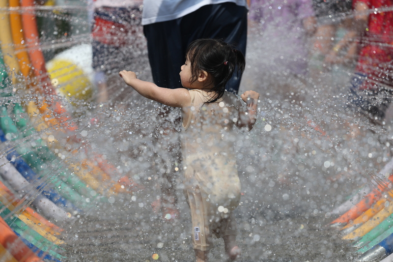 Ein kleines Mädchen spielt an einem heißen Sommertag in einem Vergnügungspark in Taipei (Foto: CNA)