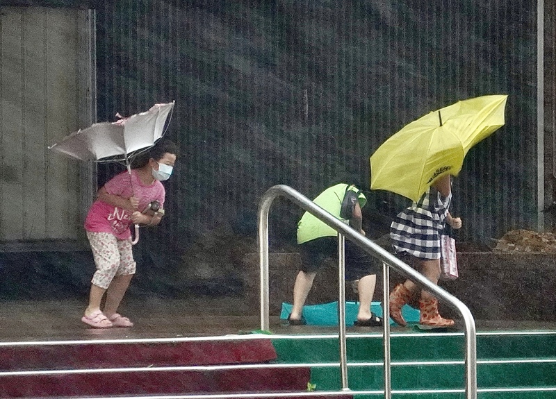 Kampf mit dem Regenschirm bei Regen und Sturm (Foto: CNA)
