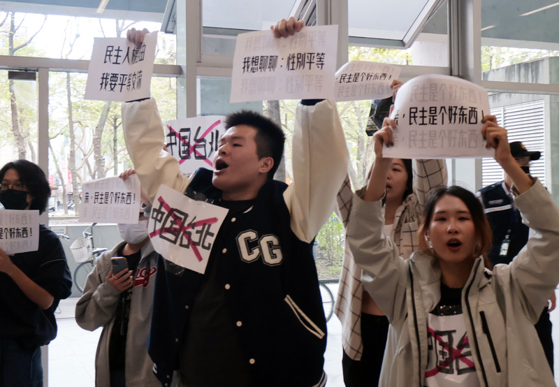 Taiwanische Studierende halten Schilder hoch mit Schildern wie: 'Demokratie ist gut', ein durchgestrichenes 'China, Taipei' und Forderungen nach einem echten Austausch auf Augenhöhe (Foto: CNA)