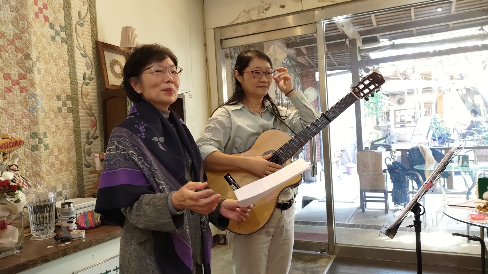 Rachel Cheng (rechts) sorgt mit Gitarre und Gesang für viel gute Stimmung bei der Abschiedsfeier im Dezember. Auch die ehemalige Repräsentantin Taiwans in der Bundesrepublik Deutschland, Agnes Hwa-Yue Chen (links), hat sie zum Mitsingen animiert (Foto: Ilon Huang)