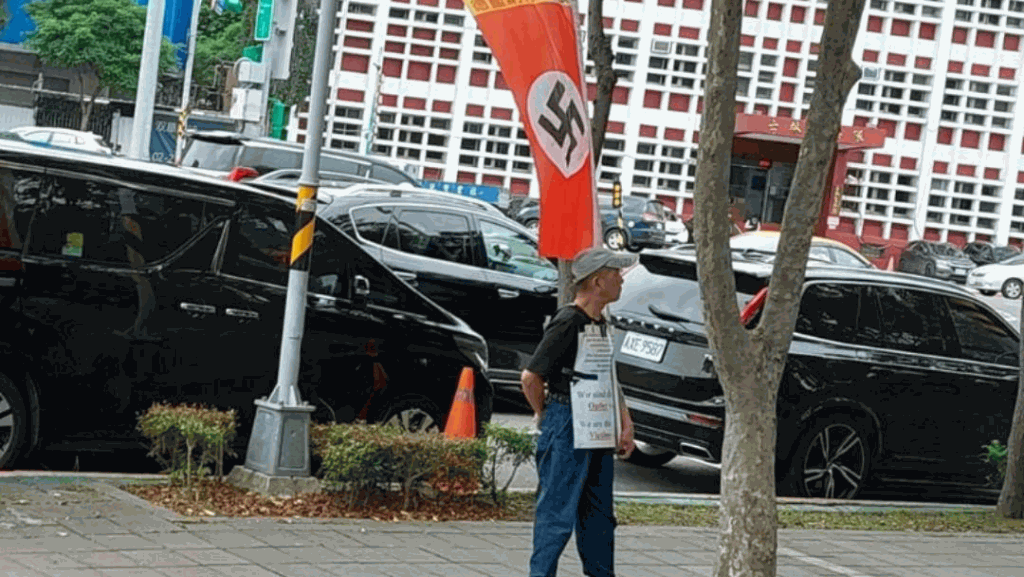 Photo d'un manifestant arborant le drapeau nazi devant l'école européenne taïwanaise (TES) (photo facebook)