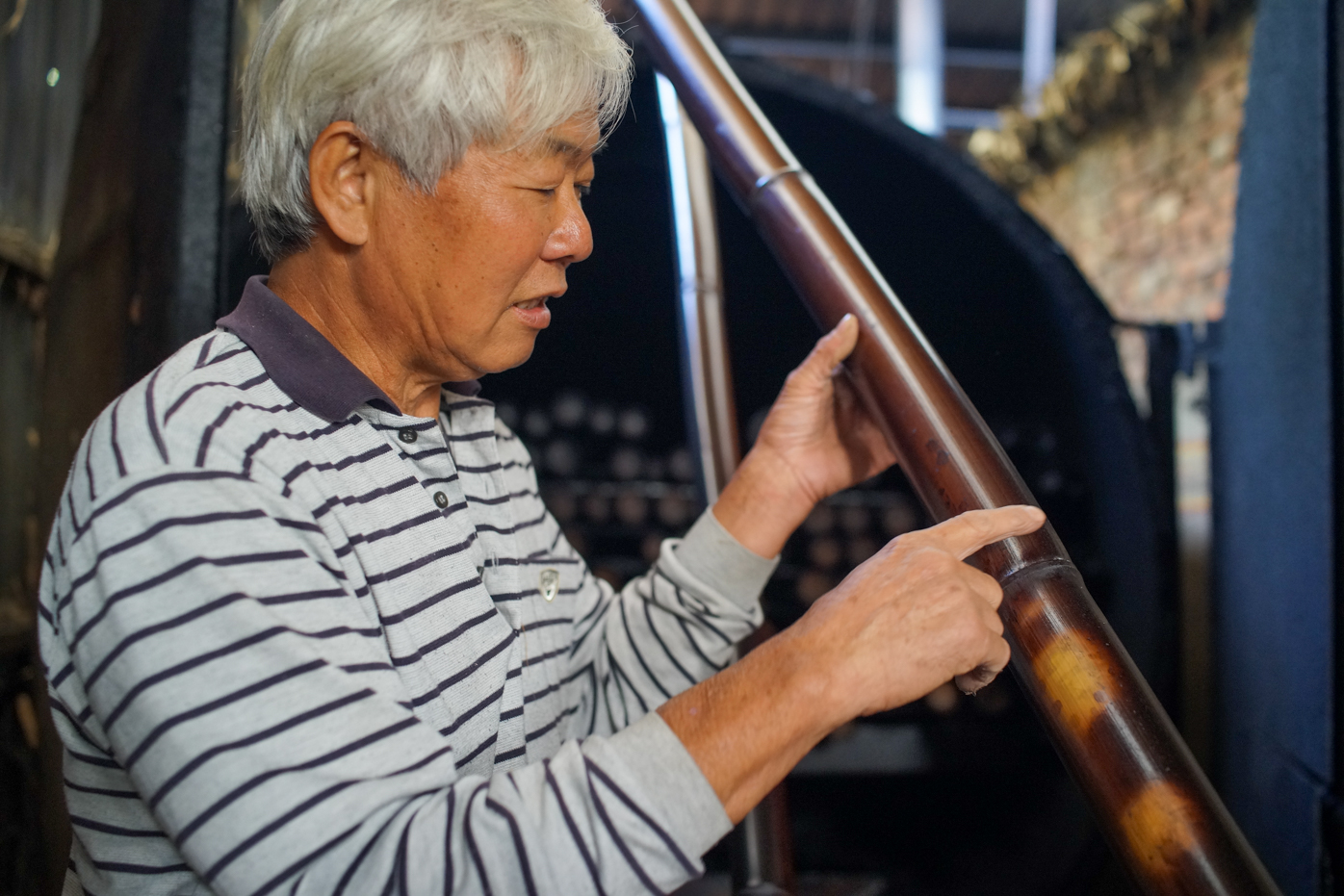 M. Liu Chao-ming dans son atelier de travail du bambou à Zhushan, nous montre un bambou traité par fumaison (photo © Sasa)