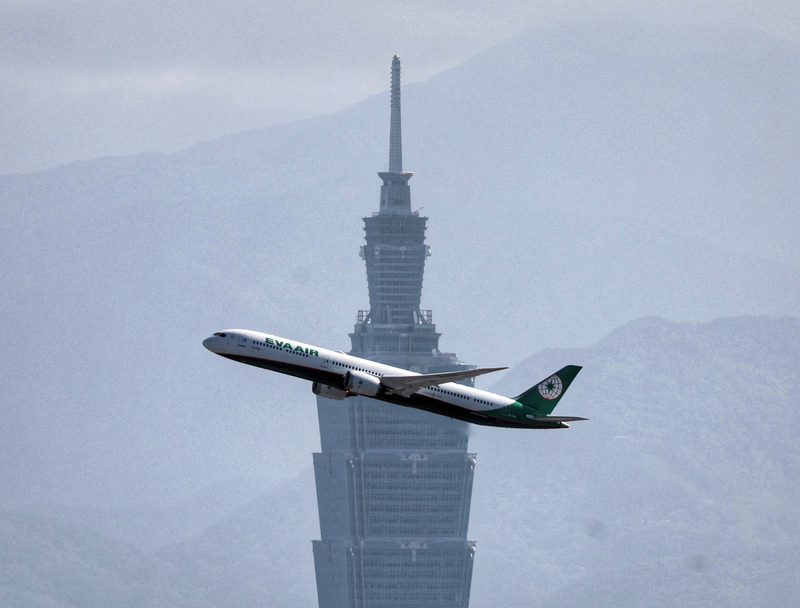 Un avion passe devant la tour 101, dans un ciel pollué (image d'illustration / CNA)