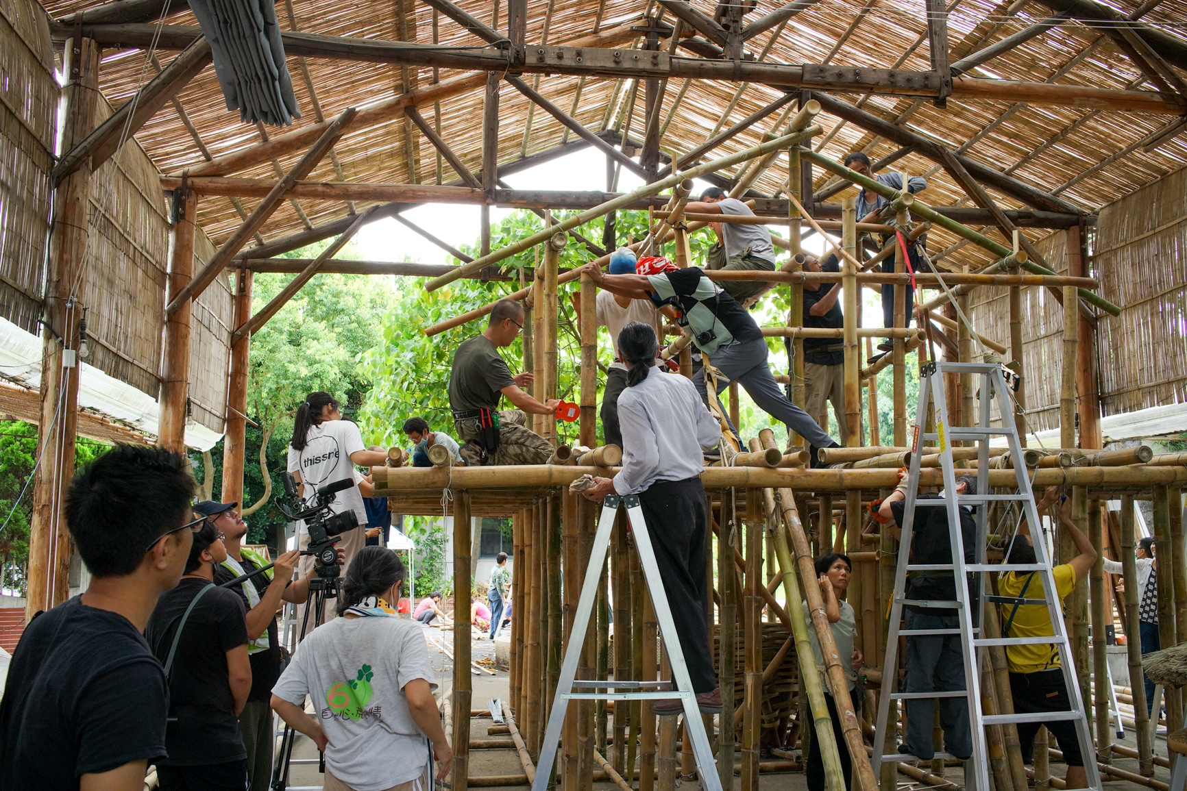 Le fils d'Ahung Masikad, Bonglai, pousse un bambou en train d'être chauffé au chalumeau pour modifier sa courbure (© Sasa)