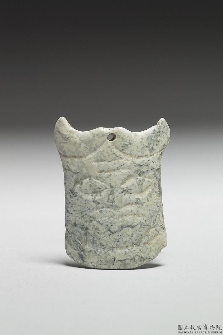 Image 7-1: Pendentif en jade en forme d'arc avec motif de masque animalier (source MNP)