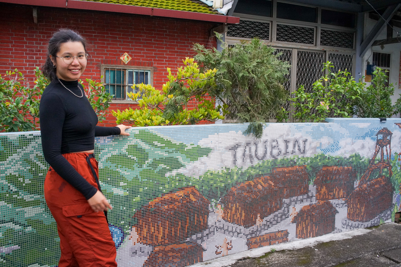 Mian Mian pose devant une mosaïque réalisée récemment dans le village de Wugonglun (Taubin en Kaxabu) (photo : Sasa)