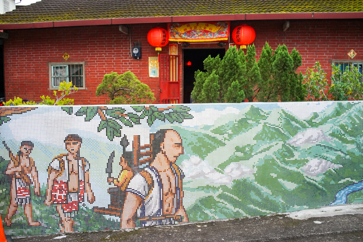 La chasse est l'une des activités représentées sur les mosaïques dans les villages Kaxabu de Puli. Cela contraste avec la maison derrière, les lanternes et l'autel aux ancêtres : deux cultures se rencontrent dans le village (photo : Sasa)