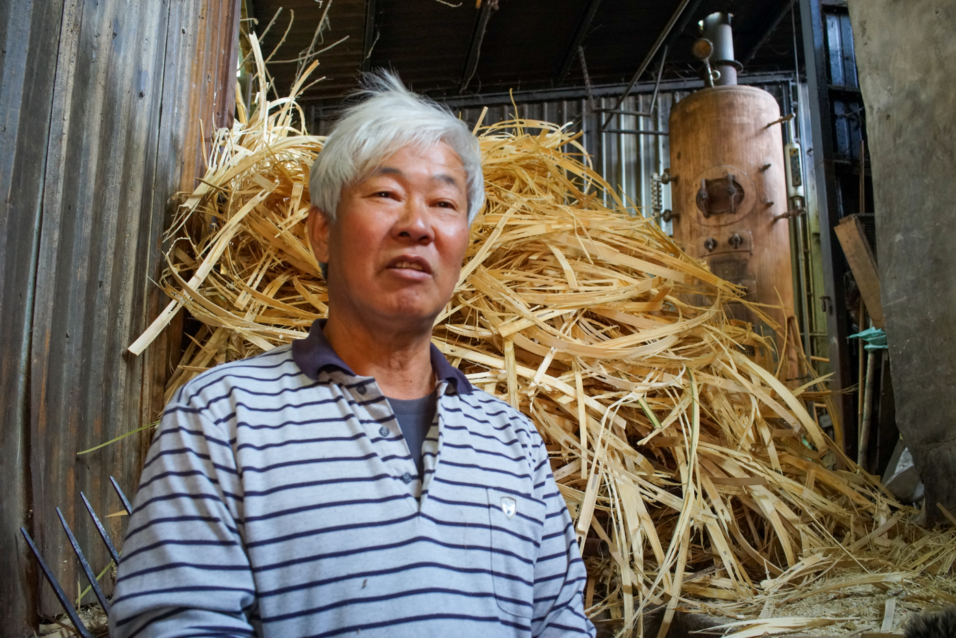 M. Liu devant des copeaux de bambou qu’il utilise comme combustibles pour ses fours (photo © Sasa)