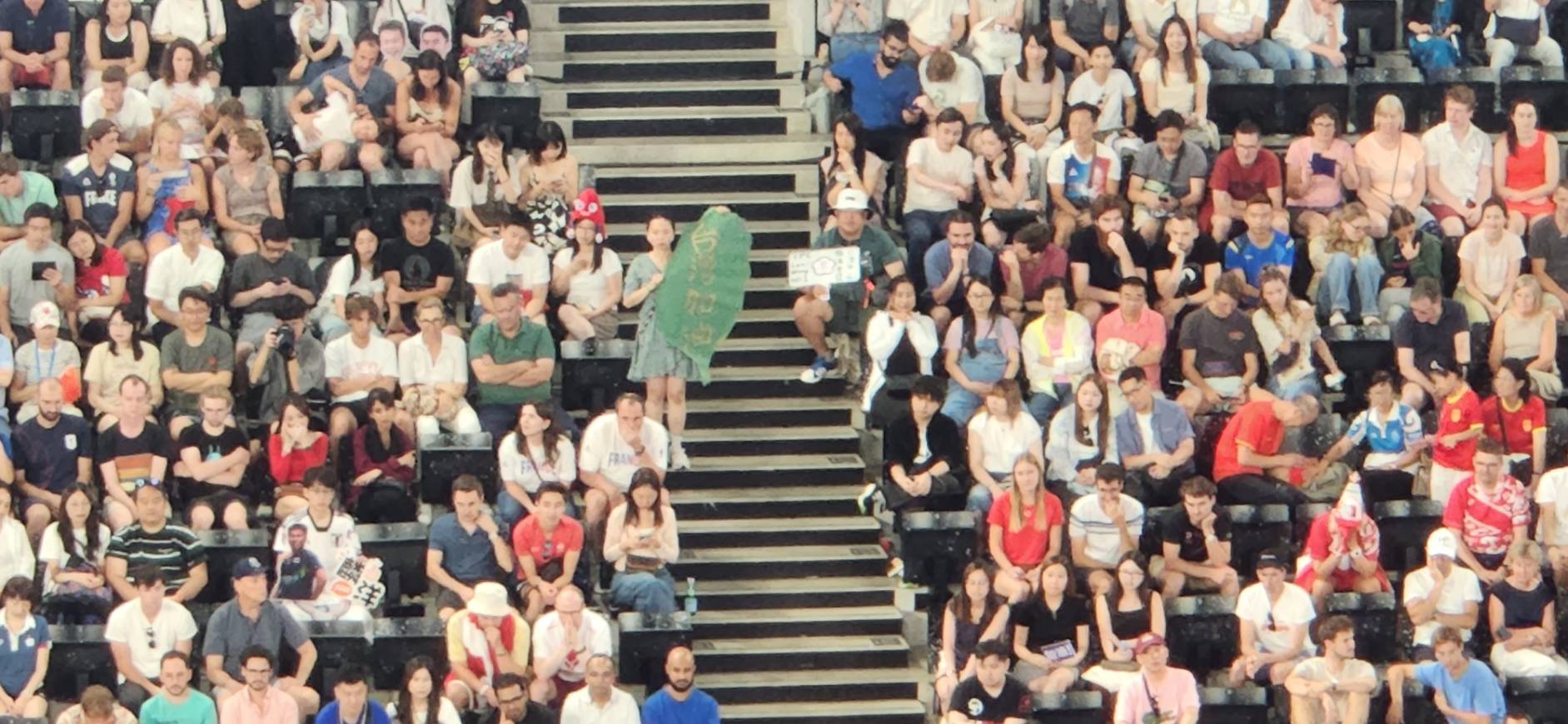 타이완 지도 모양에 '타이완 화이팅'이라는 중문을 쓴 응원 포스터(중앙 계단, 타이완 여성 양楊 씨), 응원 도중 불명의 남성에게 포스터를 빼앗기는 사태가 발생하였다. -사진: Rti