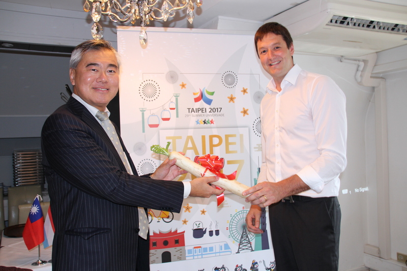 2017台北世界大學運動會即將登場，駐歐盟副代表周慶龍（左）8日送上代表好彩頭的蘿蔔給盧森堡代表隊團長霍夫曼，祝福創造佳績。<br />(圖：中央社)