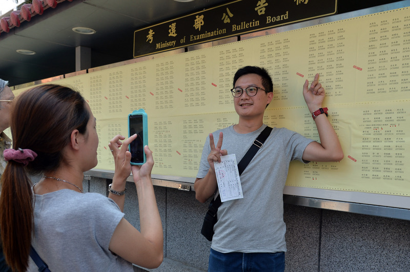 106年公務人員高等考試三級考試暨普通考試20日放榜，有考生看見自己榜上有名，開心與榜單合影。<br />(圖：中央社)