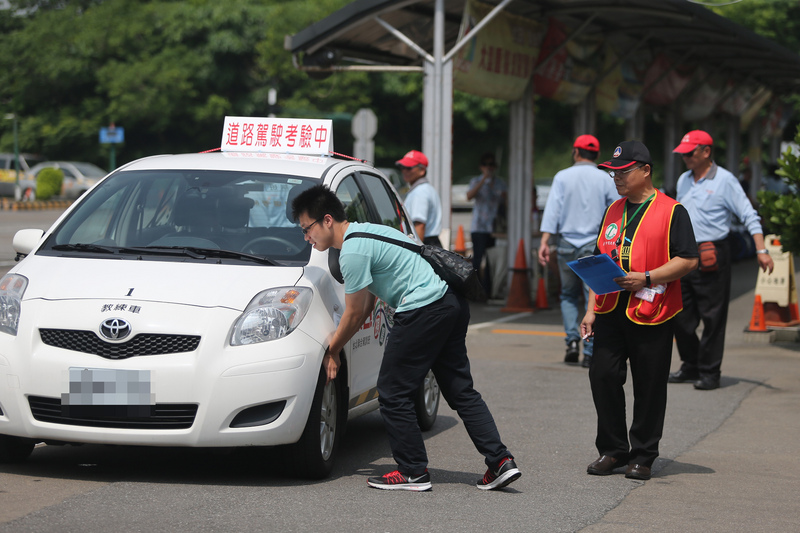 台灣小型車考照需進行場外道路考驗。圖為路考考生測試胎壓。(圖：中央社資料照片)