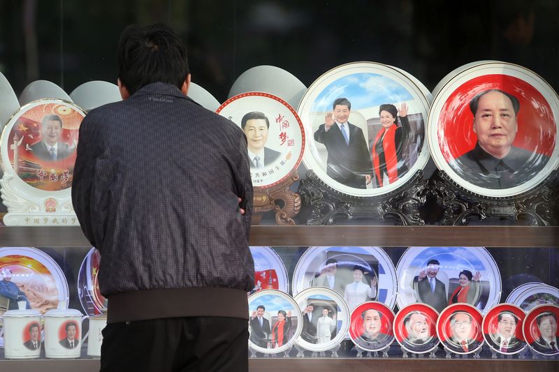 習近平成為中國領導人後，企圖實現當年毛澤東沒能實現的夢想。圖為中共19大期間，民眾在天安門廣場周邊商家觀看政治人物的周邊商品。(資料照/中央社)