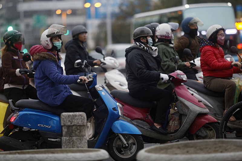 中央氣象局南區氣象中心表示，強烈大陸冷氣團7日晚間將來襲，高雄地區6日傍晚已有涼意，機車騎士們穿著厚外套保暖。<br />(圖：中央社)