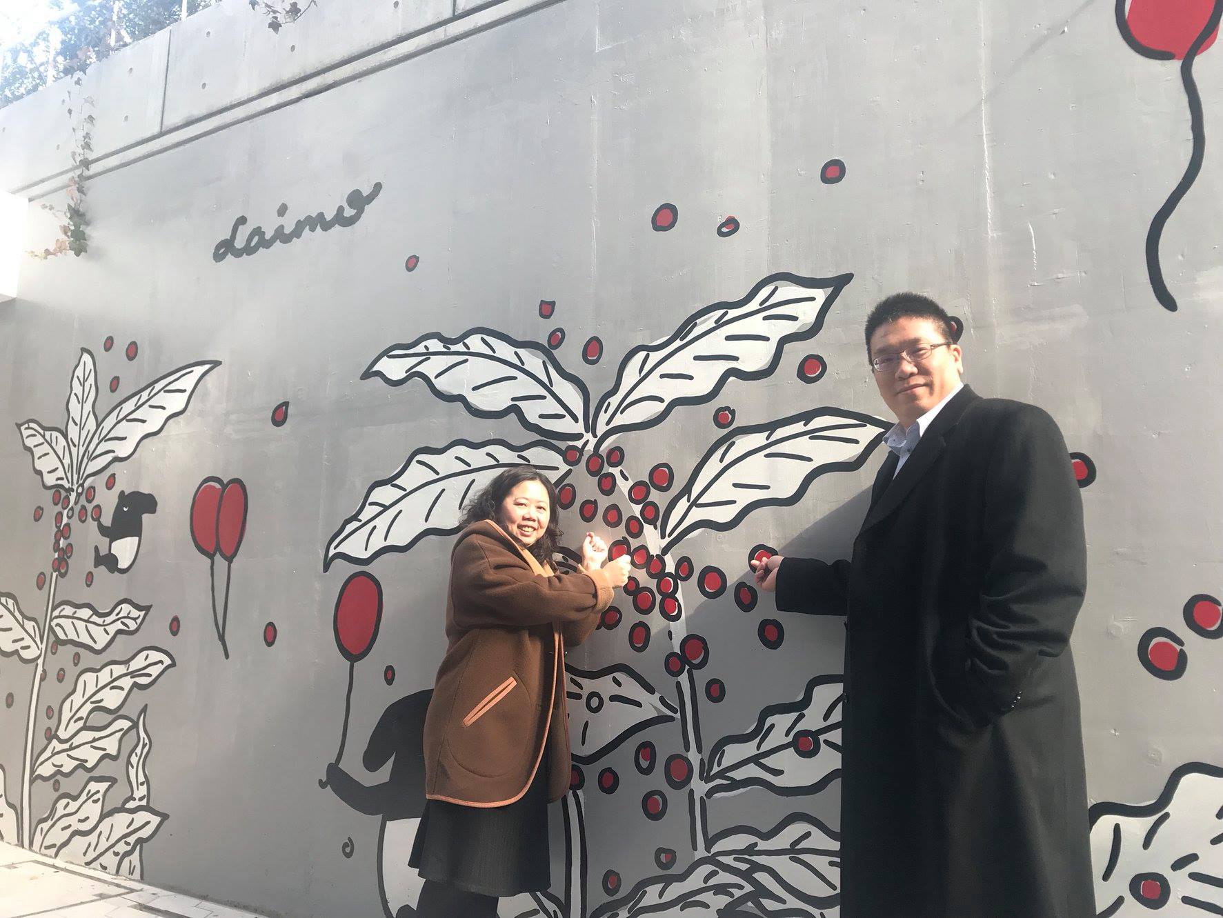 DoMo集團執行長李奇嶽(右)在東京新宿自家DoMo Café的馬來貘巨型主題牆前打卡。(李奇嶽 提供)