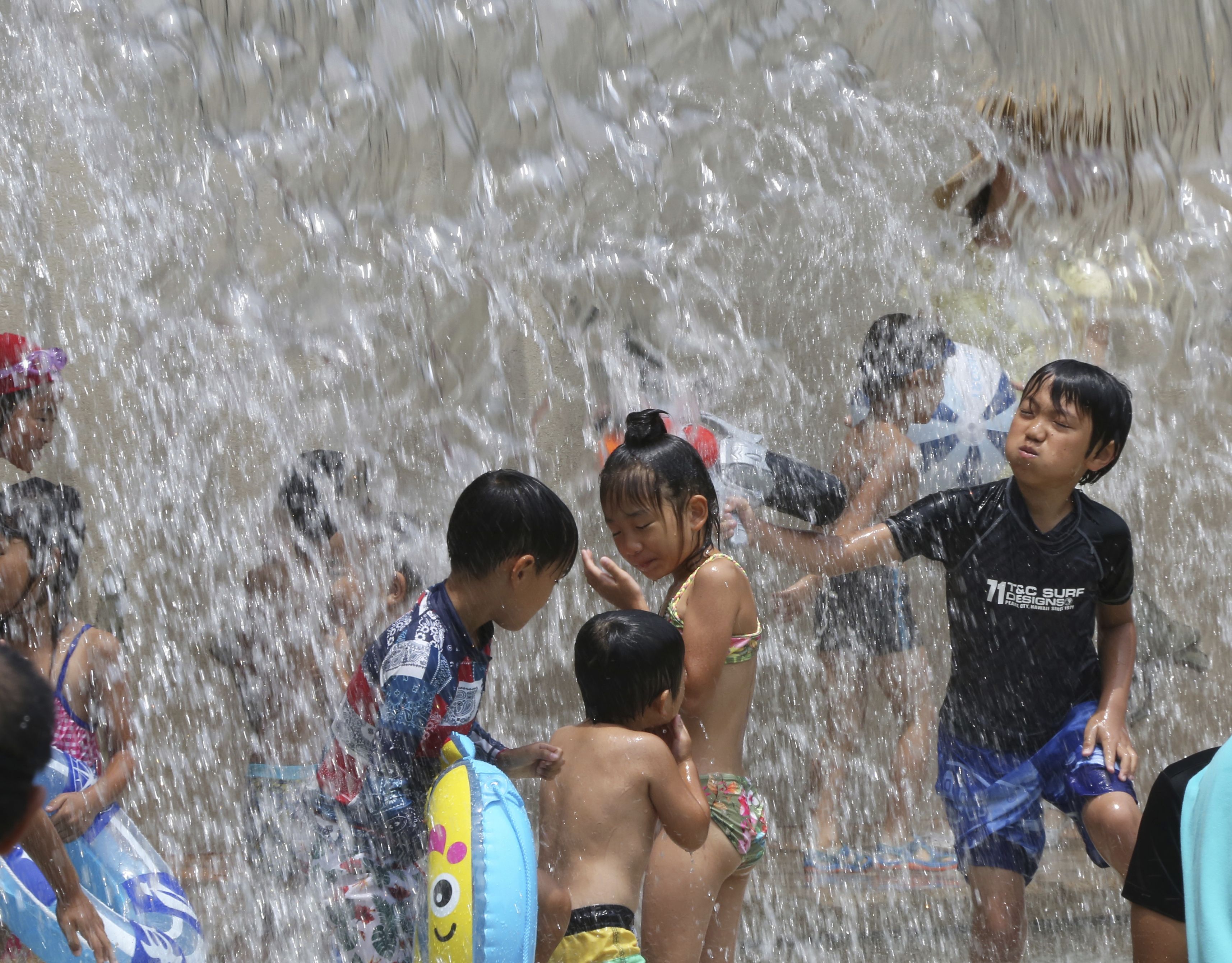 2018年7月熱浪來襲 ，東京的小朋友在公園玩水消暑。(AP\達志影像)