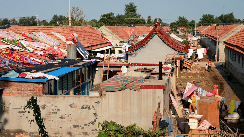 中國山東壽光近日遭遇洪害，農民在菜田裡大哭的影片在網上瘋傳引起民眾義憤。專家分析，壽光上游3座水庫同時洩洪，是造成災害的重要原因。圖為壽光市民回家整理房屋，晾曬被洪水浸泡過的傢具、衣物等物品。（中新社提供）<br />(圖：中央社)