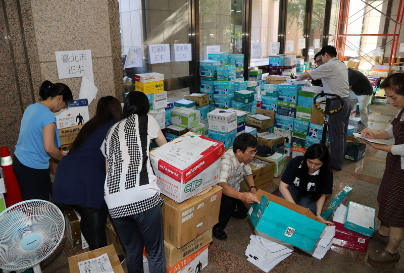 今年有多項公投合併選舉投票，連署書數量龐大。圖為中選會派出多名人員分類檢查公投連署書。<br />(圖：中央社)