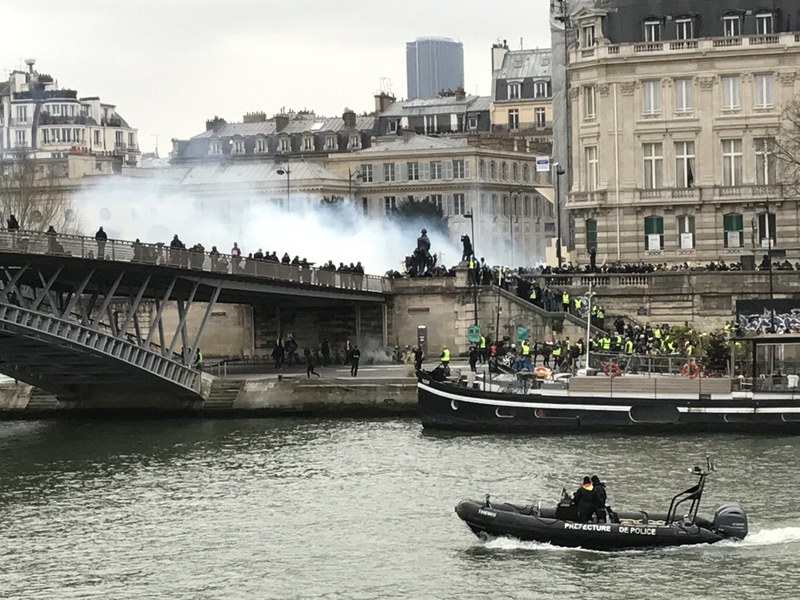 法國「黃背心」與多數民意希望恢復課徵象徵公平的富人稅，但政府無此打算，僵局難解。圖為第8波街頭行動，抗議者在奧塞美術館旁與警力對峙。(圖：中央社)