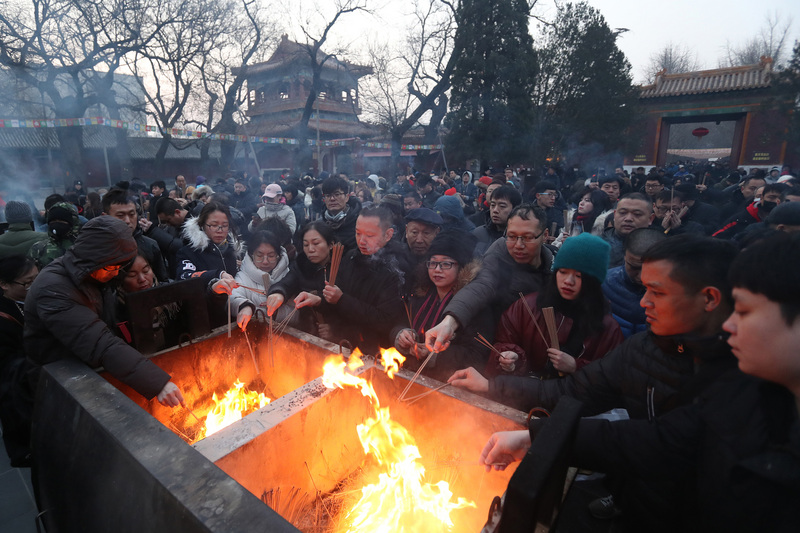 大年初一，北京雍和宮始終是中國民眾求神拜佛的大熱門，人潮向來洶湧，今年甚至有人在除夕夜就在宮門外排隊。圖為民眾爭相插香的盛況。（中新社提供 / 中央社）