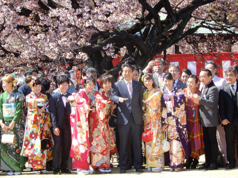 圖為安倍夫婦去年東京新宿御苑辦賞櫻大會與藝人合照。(圖:中央社檔案照片)