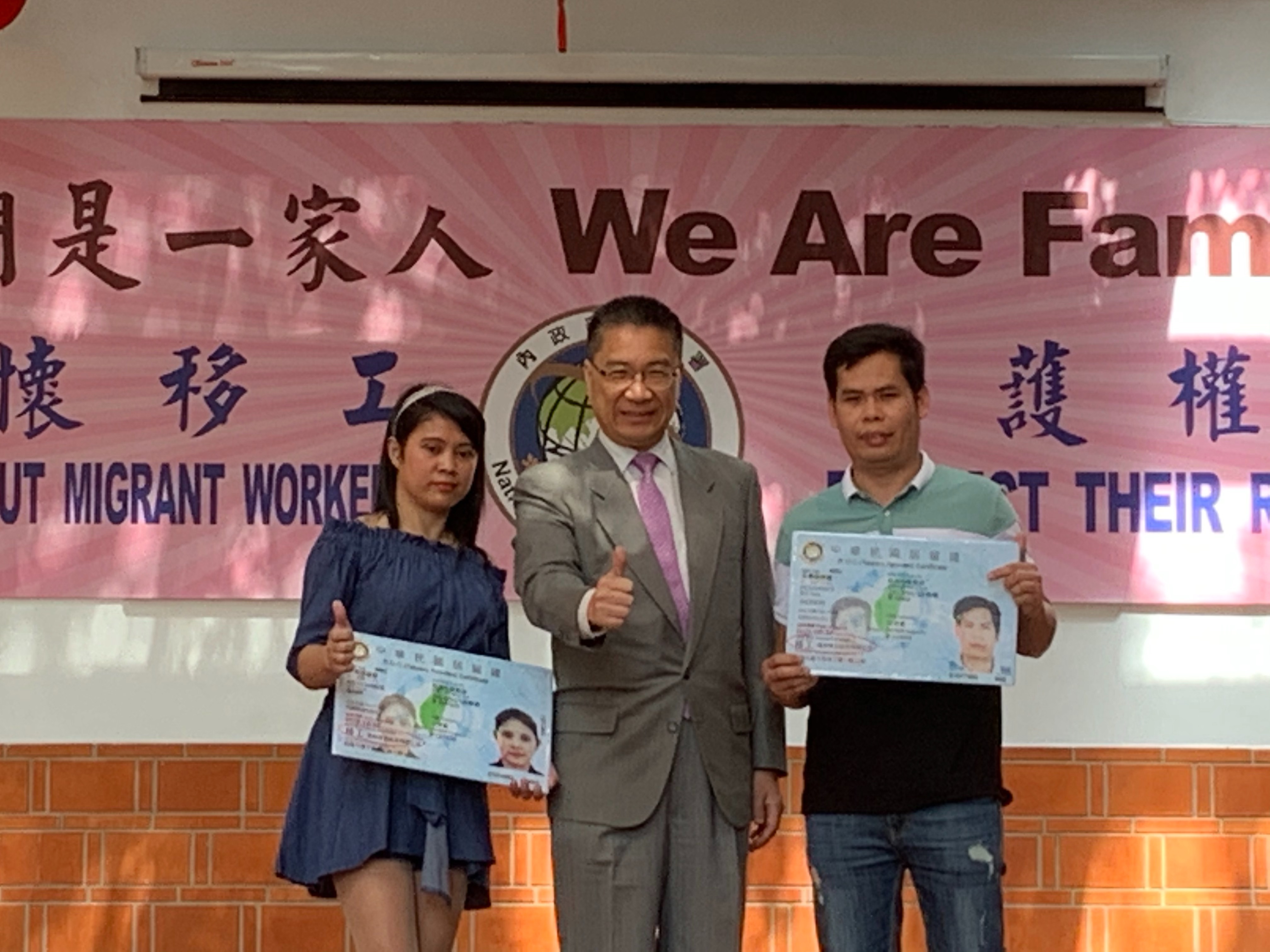 徐國勇(中)頒發更名為「移工」的新版居留證給移工朋友。(內政部提供)