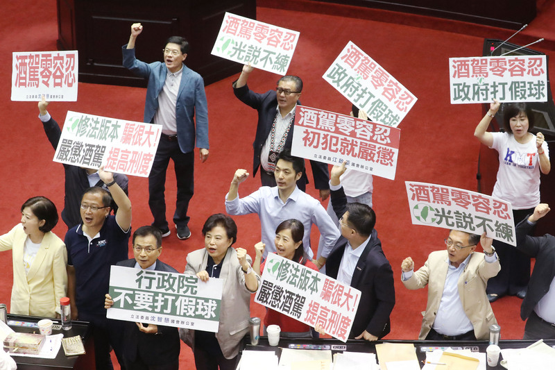 立法院會31日三讀修正通過刑法部分條文，曾犯酒駕經有罪判決確定或經緩起訴處分確定，5年內再犯酒駕因而致人於死者，處無期徒刑或5年以上有期徒刑。多名國民黨立委在議場舉標語喊口號，呼籲酒駕零容忍、初犯就嚴懲。(圖：中央社)