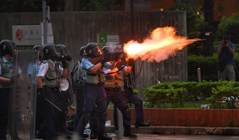 香港12日因為逃犯條例修訂草案二讀，大量民眾聚集抗議，警方午後作法轉趨強硬，下午4時後陸續向民眾發射催淚彈，抗議群眾則往周邊區域移動。(圖：中央社)