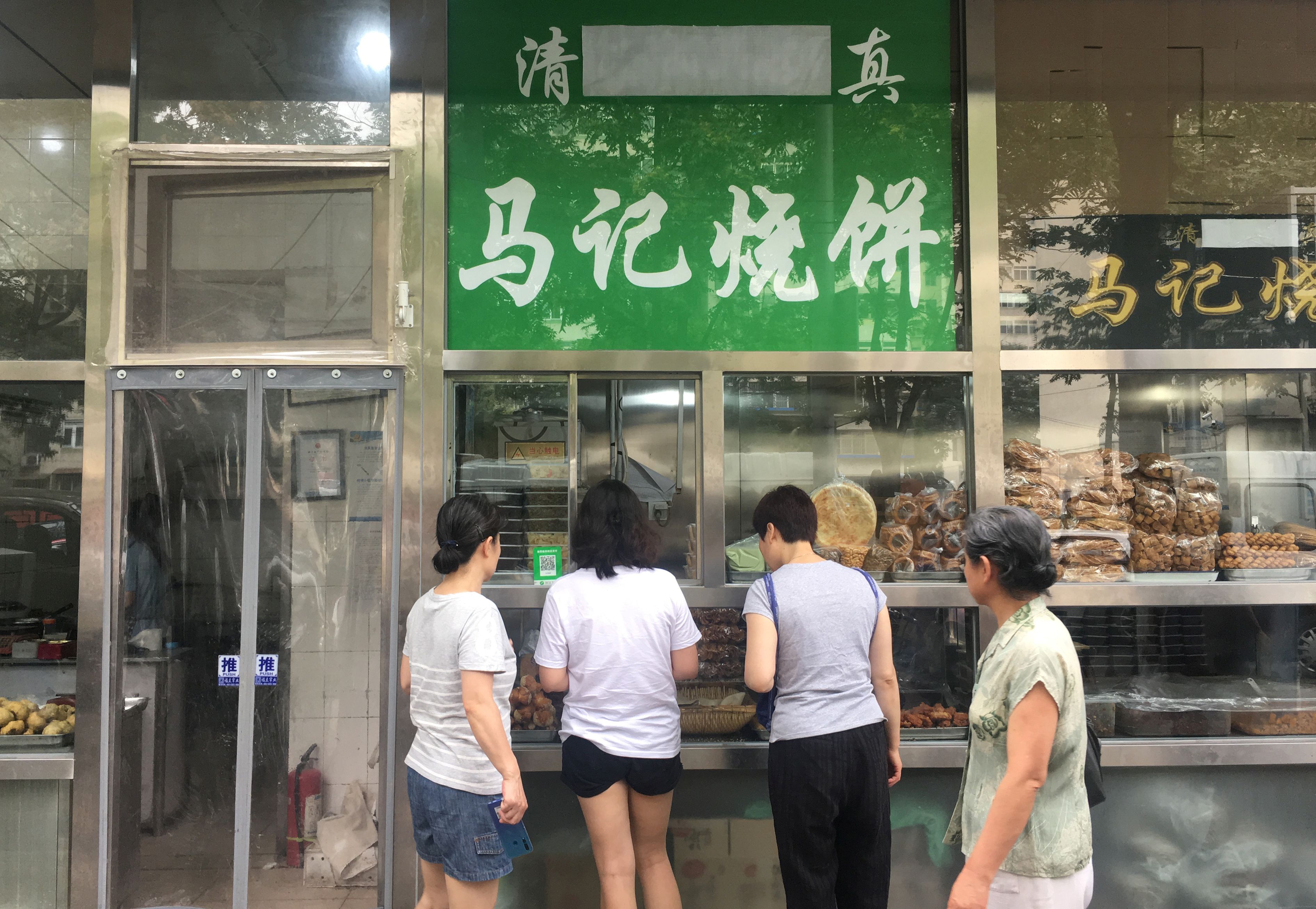 北京一家商店招牌阿拉伯文「清真」二字被遮住。(路透社/達志影像)