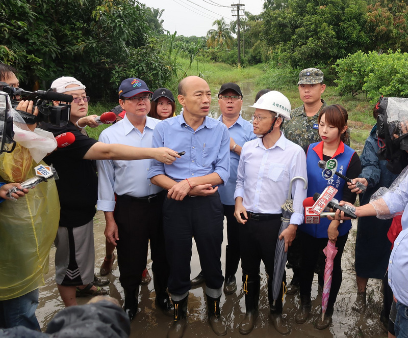 高雄市13日一場大雷雨造成多處有積淹水災情，高雄市長韓國瑜（前中）由工務局長吳明昌（前左2）及水利局長李戎威（前右2）陪同勘災。(圖:中央社檔案照片)