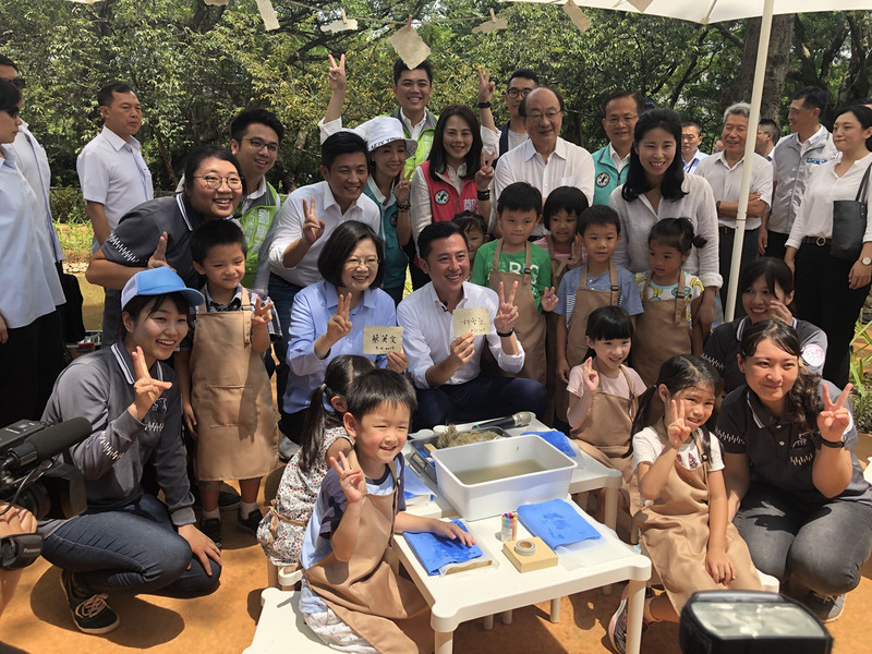 蔡英文總統（2排左3）到預計於年底完工重新開放的新竹市立動物園，搶先參觀明星動物河馬「樂樂」的新家，也與小朋友們一起手做河馬便便紙。(圖：中央社)