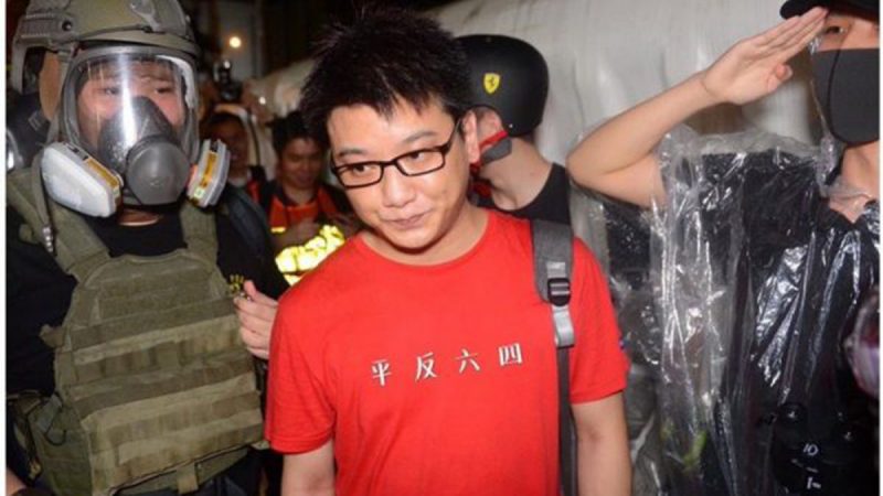 中國籍紅衣男因在金鐘近距離拍攝示威者「大頭照」而被包圍。(網路圖片)