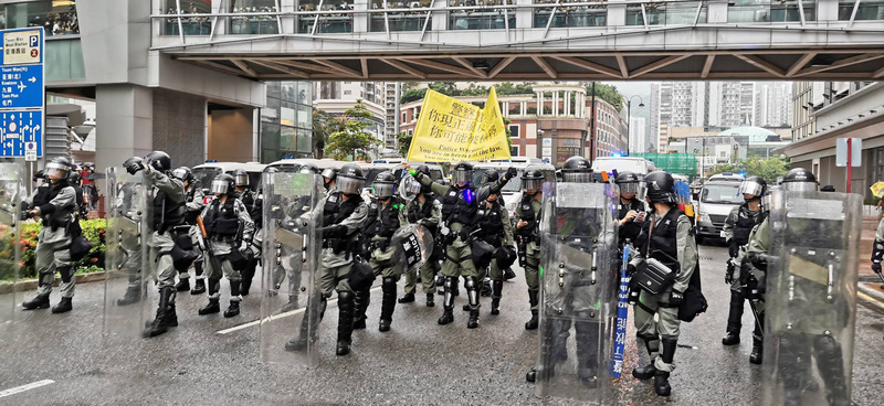 香港「反送中」支持者25日在新界荃灣舉辦荃葵青遊行，部份示威者走上當地的楊屋道，導致道路被堵，與在場戒備的警員對峙。警方則要求示威者立即離開。(圖:中央社)