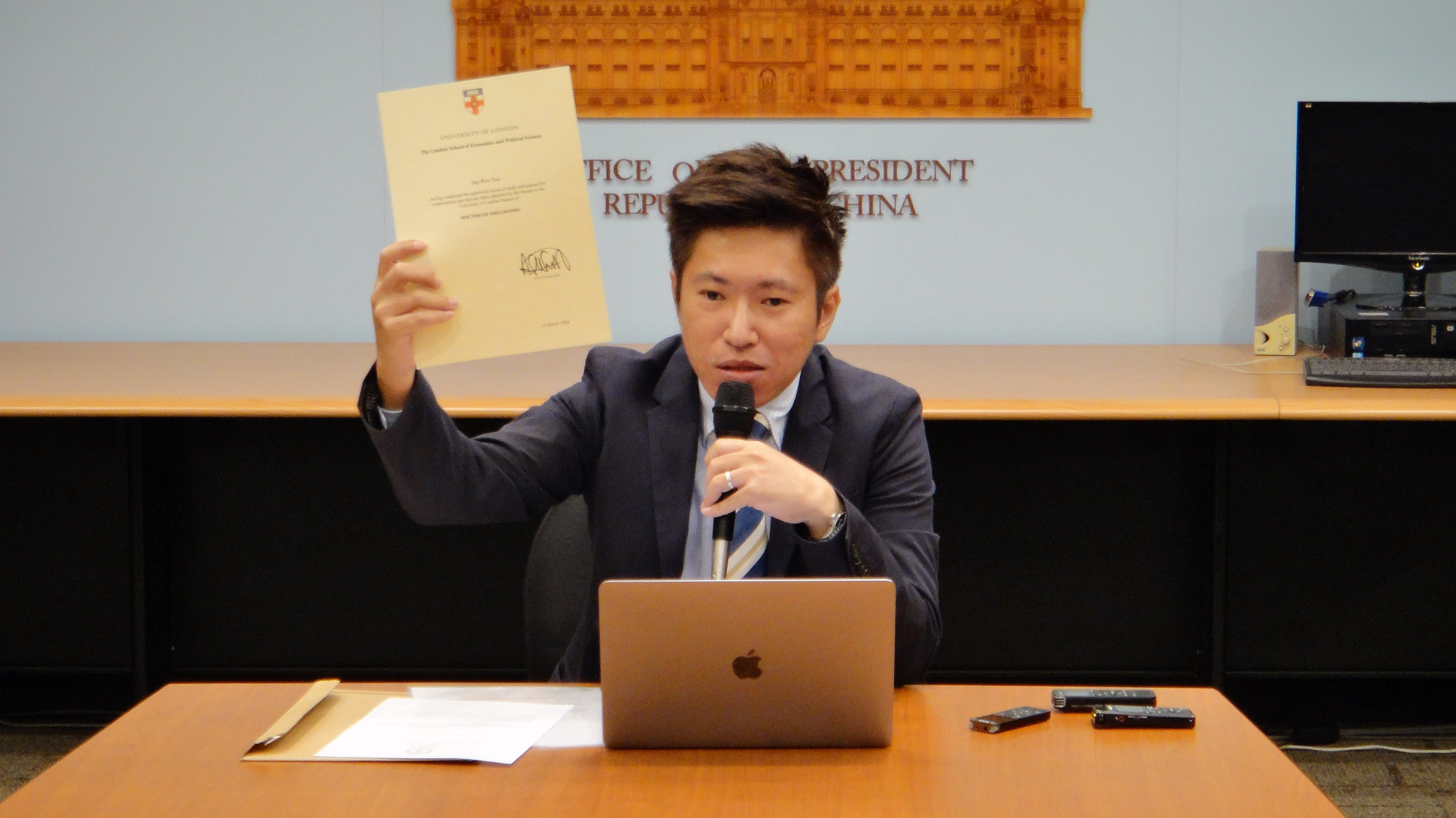 總統府發言人張惇涵秀出蔡英文總統LSE學位證明。(歐陽夢萍 攝)