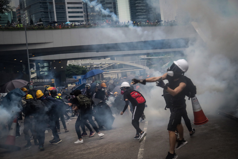 香港反送中，8月31日發起主題為「為香港罪人祈禱」遊行，大批示威者響應參與，警方傍晚在政府總部外發射催淚彈，有示威者並未馬上撤退，而是撿起催淚彈往回丟。(資料照片/中央社)