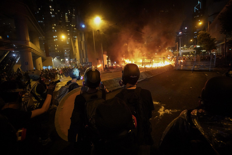 香港反送中運動8月31日傍晚上演暴力抗爭場面，除警方發射催淚彈、出動水砲車外，示威者也頻丟汽油彈等，雙方對峙至入夜仍持續，灣仔一帶街道燃起熊熊火光。(圖：中央社)
