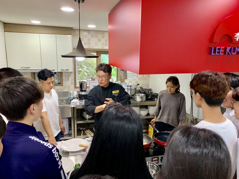 為使中華料理能夠在旅韓華僑年輕一代傳承下去，被韓國媒體讚譽為中華名廚的呂敬來（中）19日在漢城僑中向烹飪社團學生傳授廚藝。(圖：中央社)