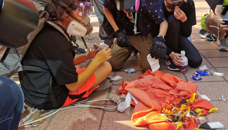 圖為香港反送中人士21日下午舉行遊行，其中有人在屯門大會堂旁拉下中國國旗並燒燬。(資料照片/CNA)