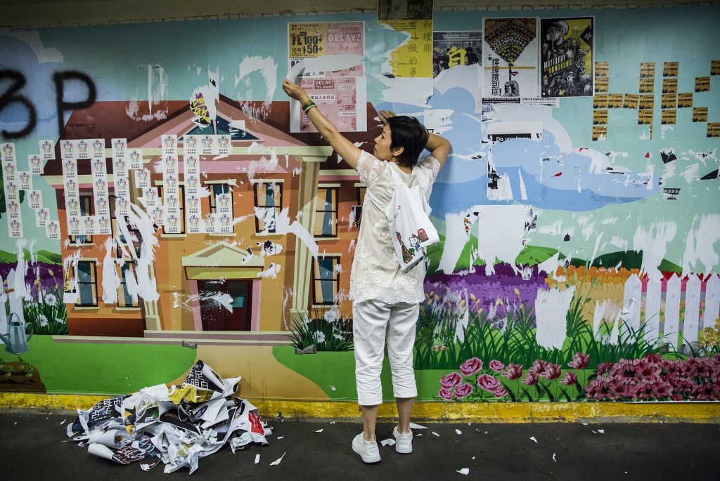 香港多地民眾21日響應號召，清除區內宣傳民主自由的「連儂牆」，遭「反送中」者阻止，雙方發生少許摩擦。(AFP)