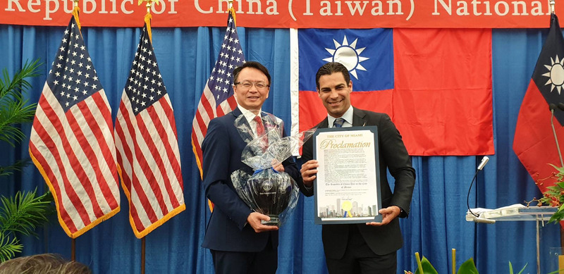 佛州邁阿密市市長斯瓦瑞茲（右）致贈賀狀及紀念品給駐邁阿密經文處處長錢冠州（左）。（邁阿密經文處提供）