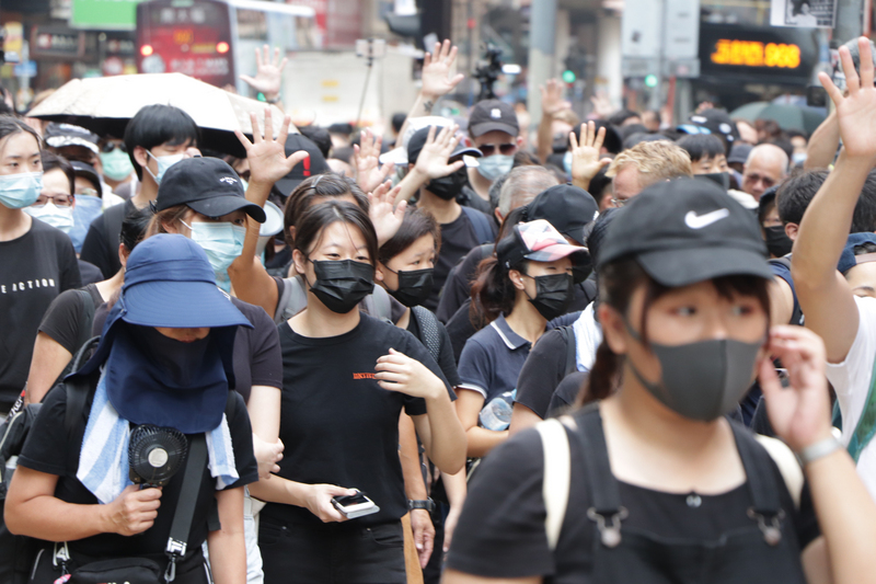 香港反送中示威者不理會港府祭出禁蒙面法，5日遊行時依舊戴上口罩。(圖：中央社)