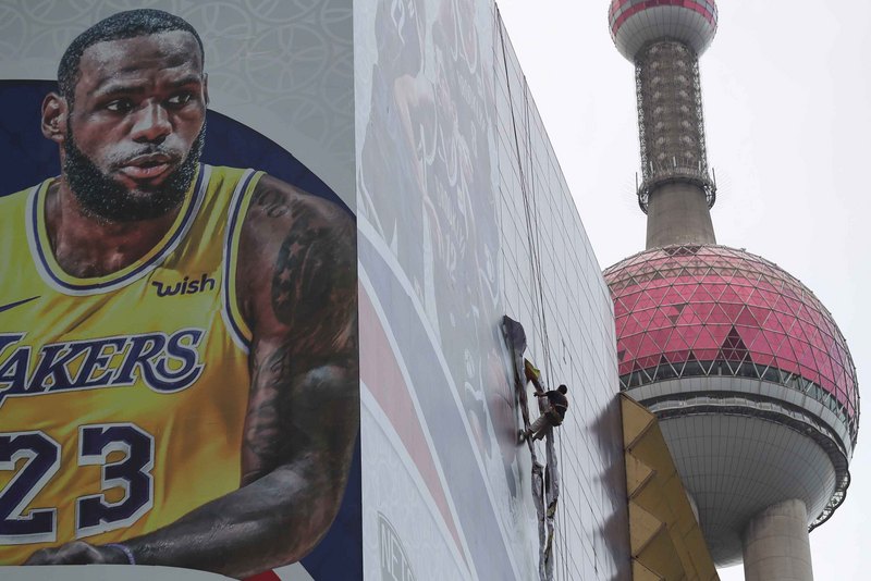 美國職籃(NBA)風波延燒，美國部分人士指中國正利用市場和商業手段操控美企，強迫放棄價值觀。圖為10月9日工人拆除NBA巨幅海報。（中新社提供）