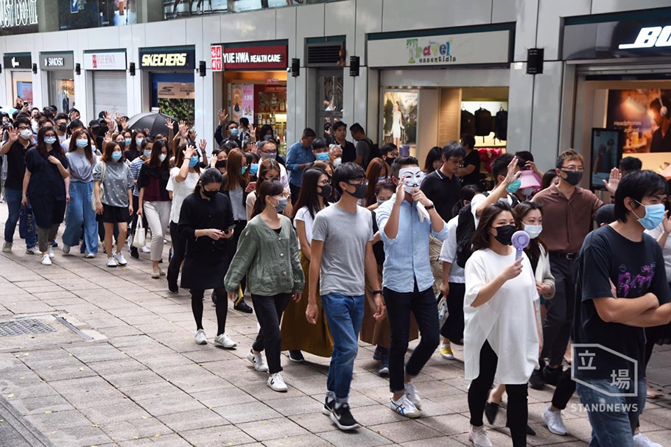 香港數以百計市民沿彌敦道遊行，經過尖沙咀警署時，遮右眼抗議。(立場新聞提供)