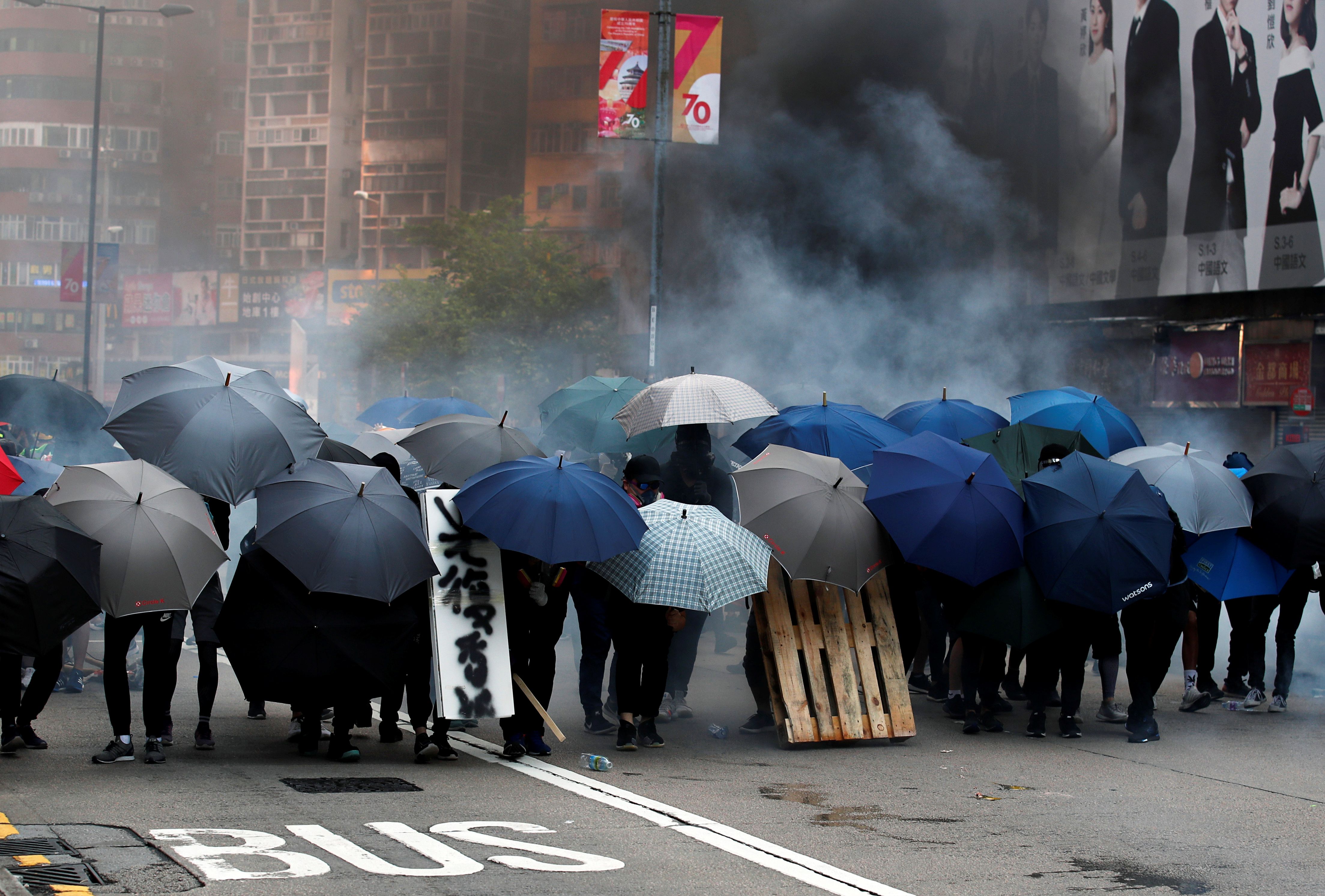 香港示威者20日用雨傘抵擋警方的催淚彈。(路透社/達志影像)