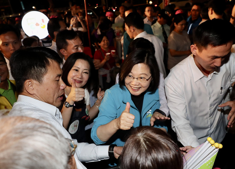 總統蔡英文25日晚間為民進黨籍立委參選人輔選站台，離去時和現場熱情支持民眾互動致意。(圖：中央社)