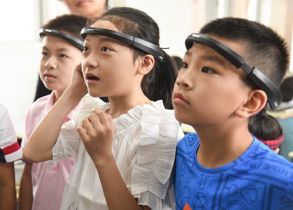 浙江省一所小學的學生被要求配戴「監控頭環」上課，以監測其注意力，並將相關資訊發送給家長。(圖取自微博)