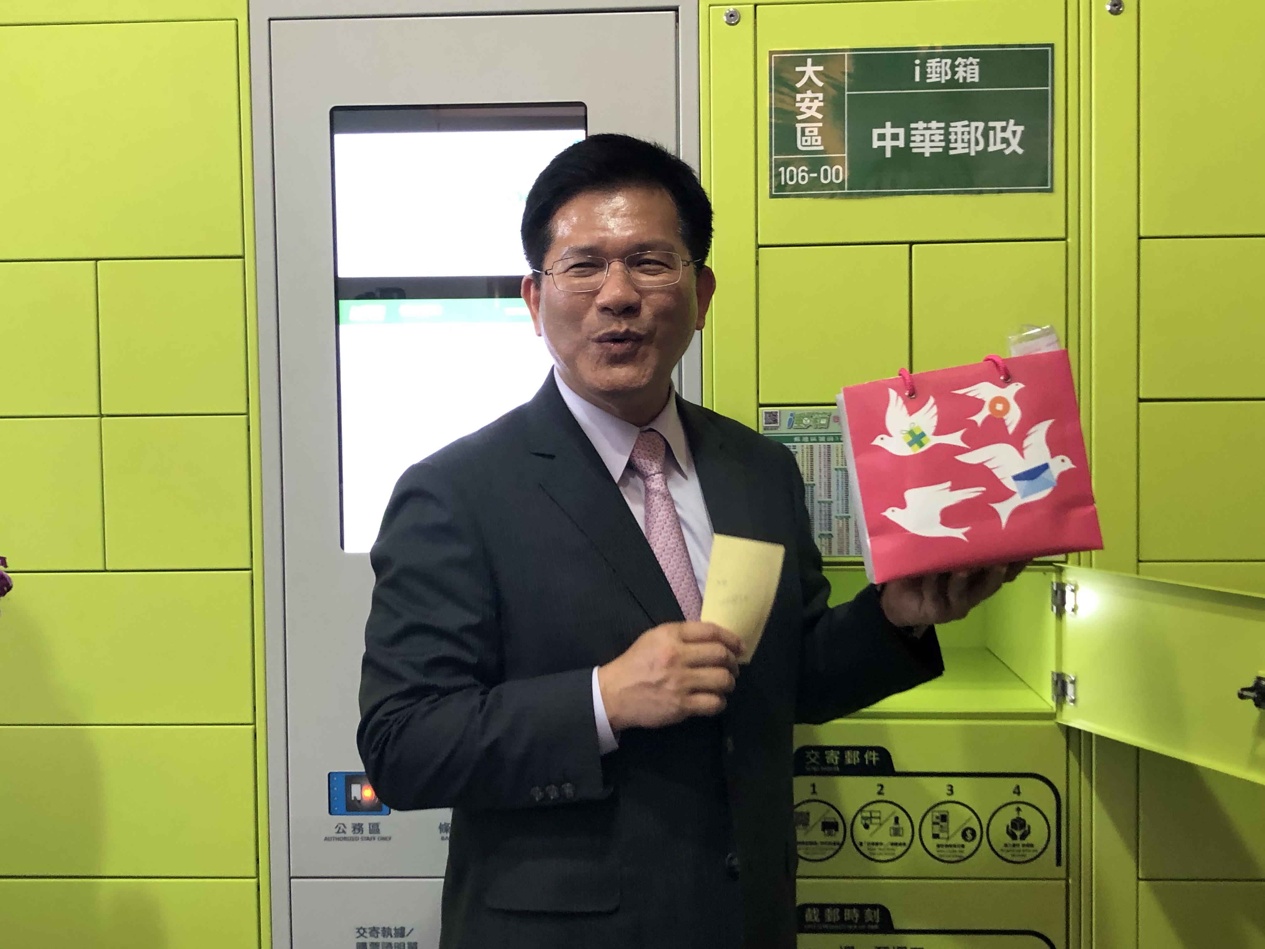 交通部長林佳龍5日在「跨境新物流-智慧全通路」產業論壇會場，親自體驗從台灣智慧物流的最後一哩路「中華郵政i郵箱」領取包裹的驚喜。(吳琍君 攝)