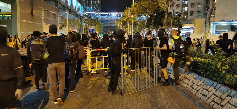 香港科技大學學生周梓樂日前墜樓後不治身亡。大批港人8日晚間參加在多區舉行的悼念活動。圖為有示威者晚間10時許開始堵塞事發地尚德(村)停車埸外的街道。(圖：中央社)