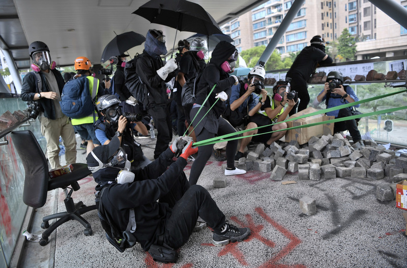 反送中示威者11月12日集結於香港歌和老街近城市大學學生宿舍一段，警方到場驅散時，在橋上的示威者以大型彈弓向警員發射石塊並丟擲汽油彈。(資料照片/ 中通社提供）(圖：中央社)